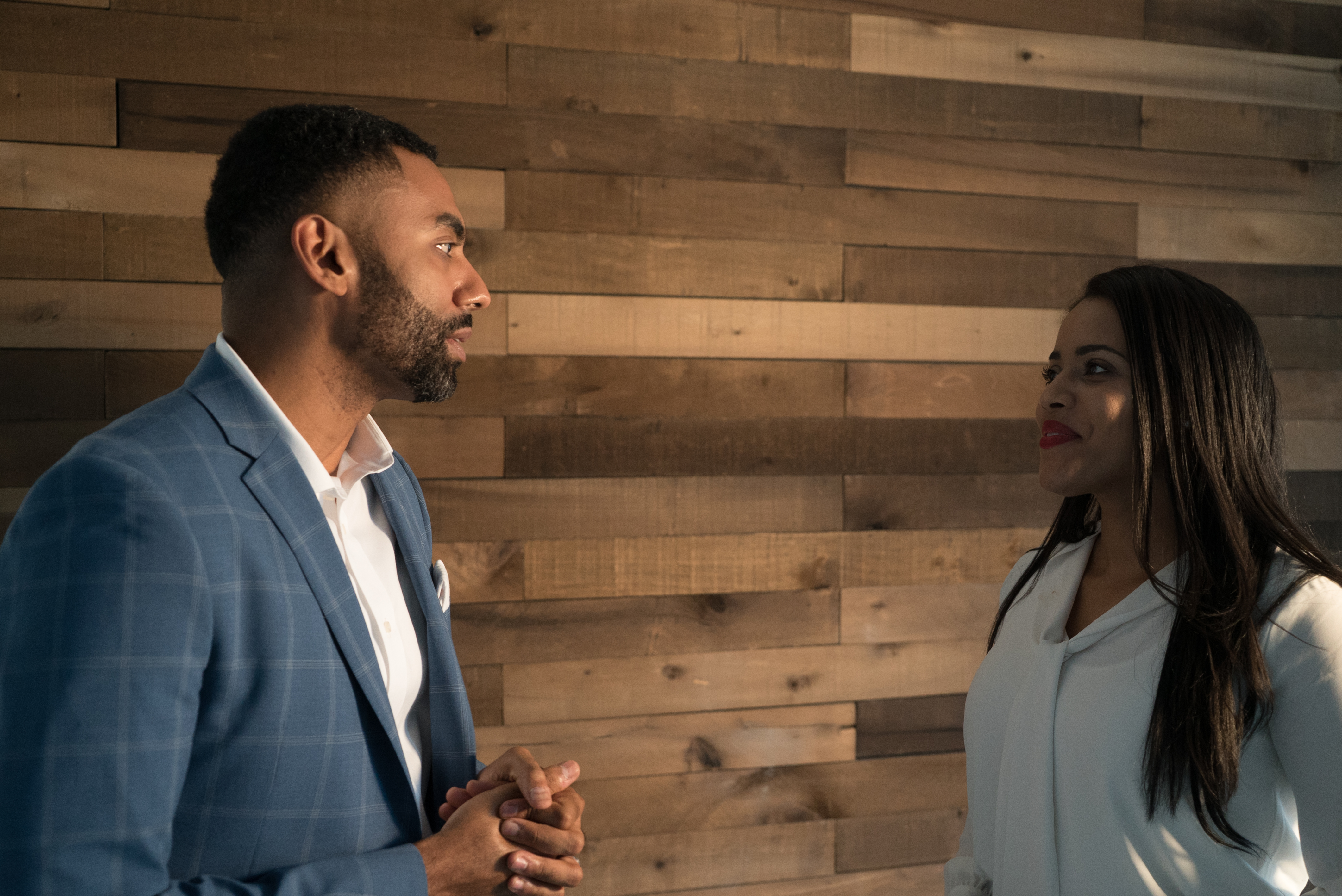 Career Coach Juan wearing a suit talking with a businesswoman